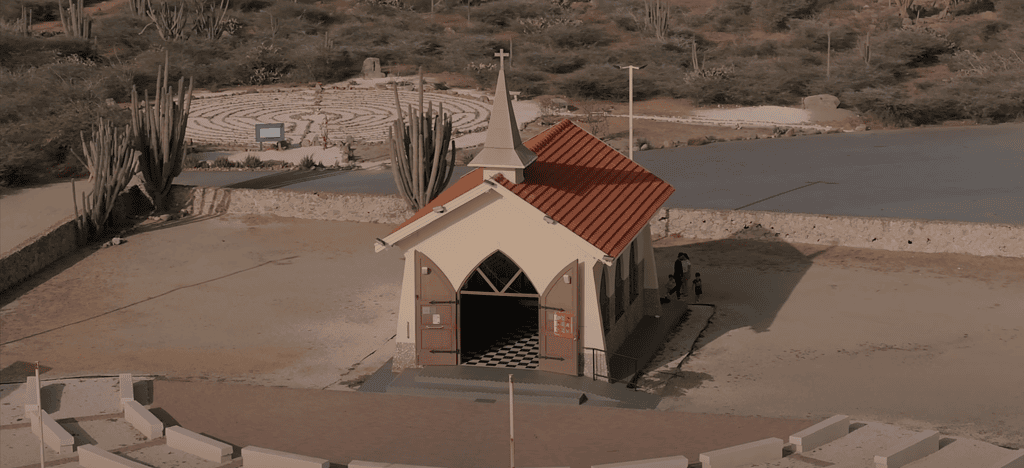 Aerial view of Alto Vista Chapel in Aruba with cactus and labyrinth garden nearby.