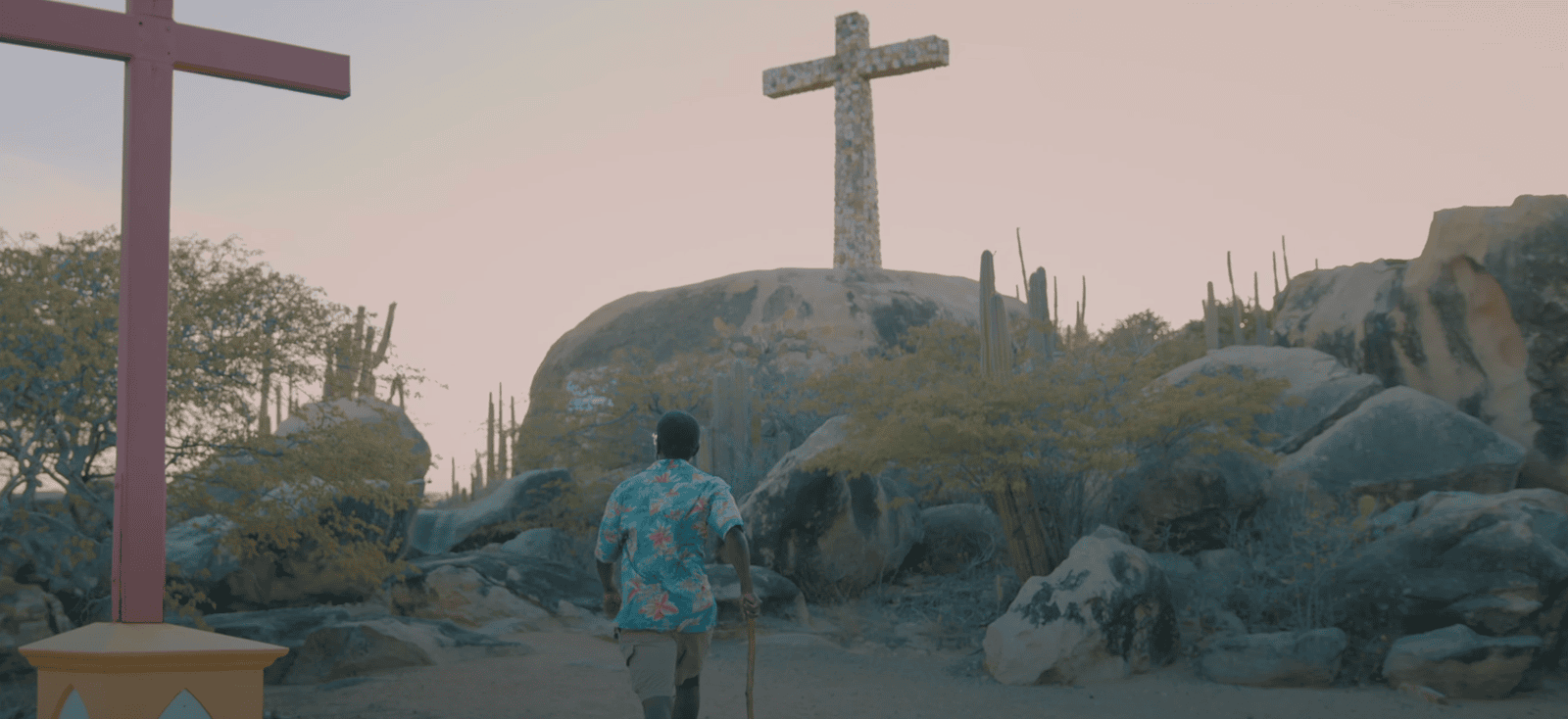 Scenic view of Canashito in Santa Cruz, Aruba, with large stone cross, symbolizing Spanish colonial influence and Catholic heritage.