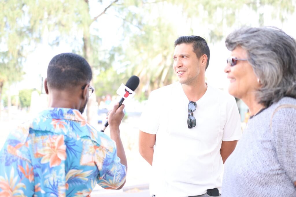 Sly'n Tour guide interviewing two people outdoors in Oranjestad during a discussion about Aruba’s flag history.