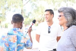Sly'n Tour guide interviewing two people outdoors in Oranjestad during a discussion about Aruba’s flag history.