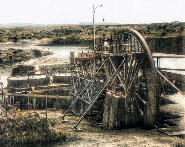 Rustic water wheel mill machinery at Djis Pa Hari, showcasing traditional water-powered technology surrounded by natural landscape.