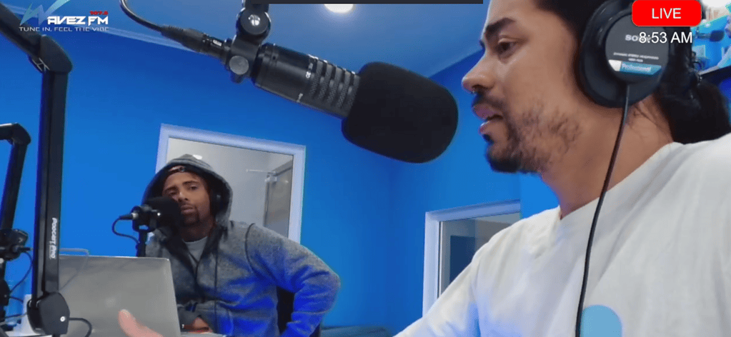 Djis Pa Hari podcast recording session with two hosts speaking into microphones in a vibrant blue studio environment.